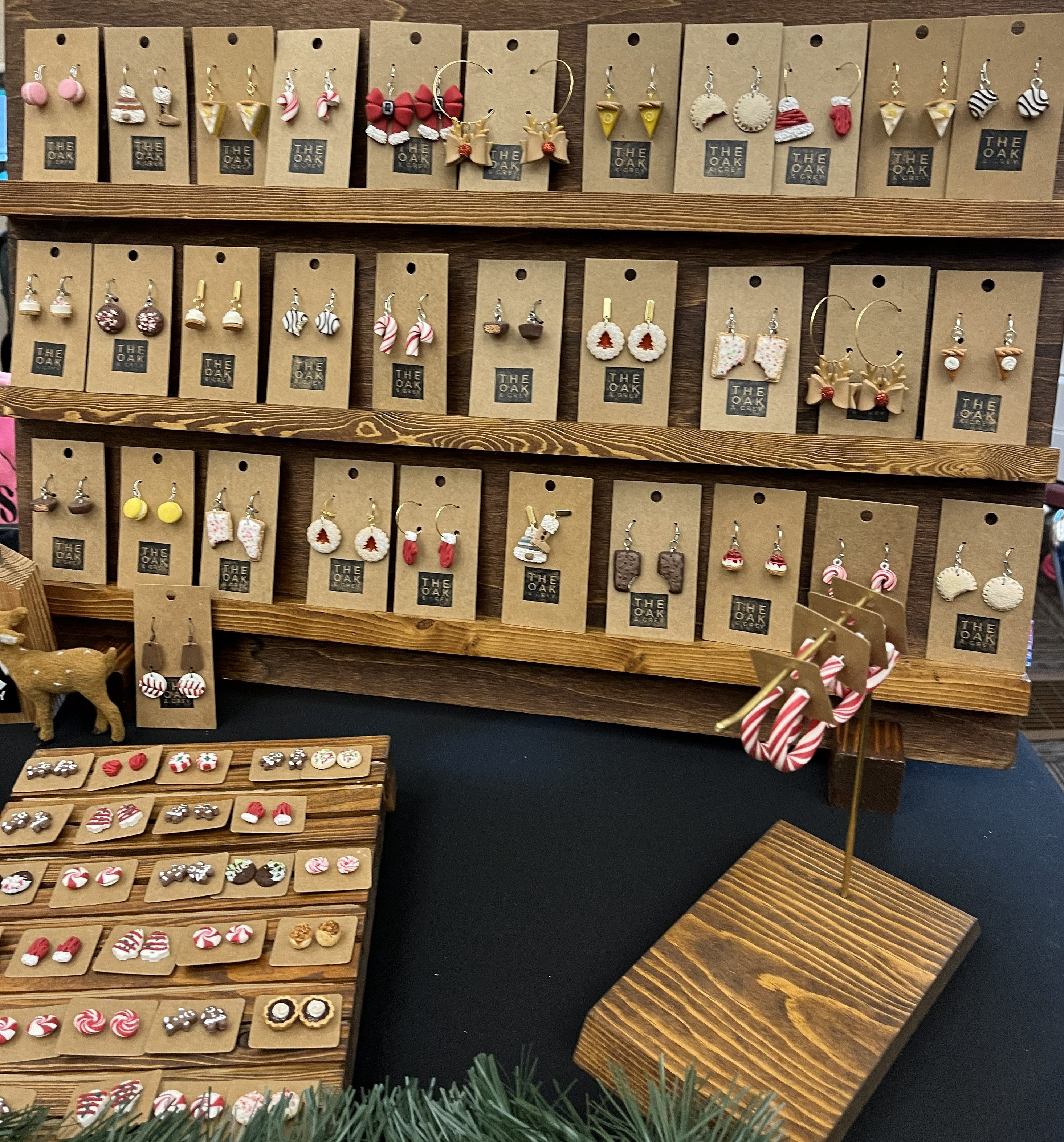 Display of various earrings on wooden shelves and stands.